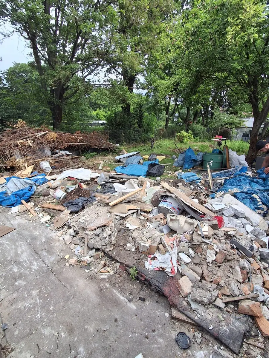 Garten voller Bauschutt und Sperrmüll vor der Räumung
