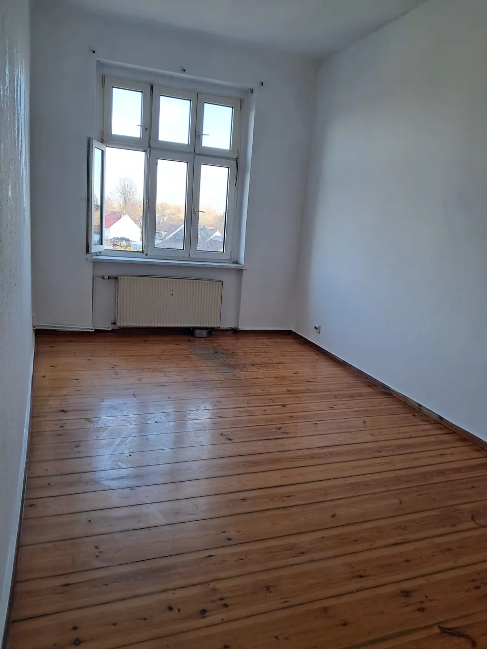 Leeres, sauberes Zimmer mit aufbereitetem Holzboden
